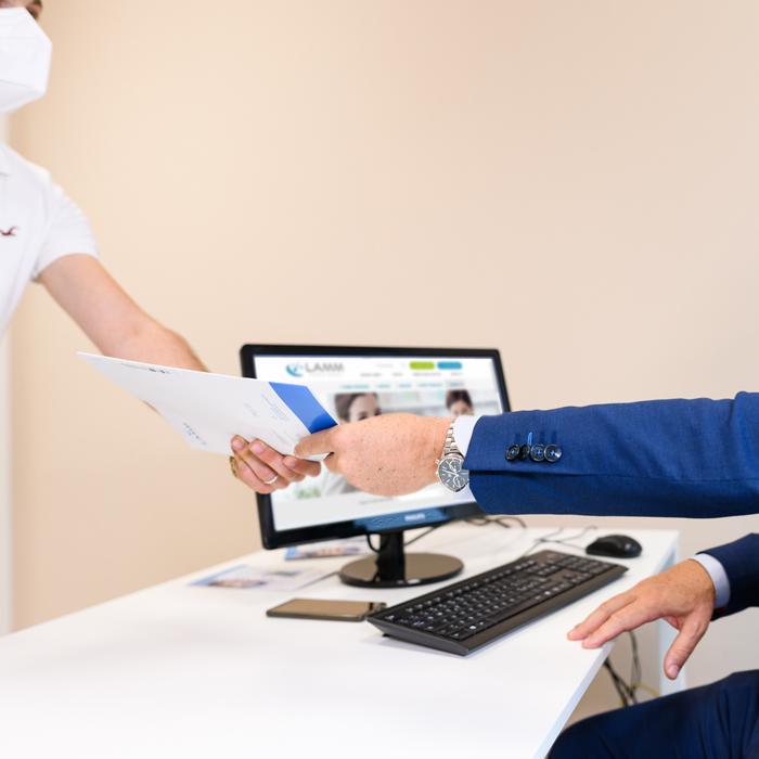 Passaggio di una cartella sanitaria tra lavoratore e medico